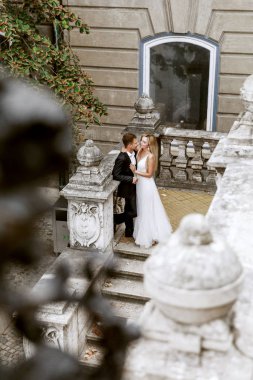Gelin ve damat kente sokak sarılma. Evlilik çift aşık. Lüks yapay elmas elbise. Sıcak yaz günlerinde.