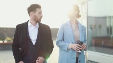 Çekici işkadını kahve gülümseyen ortağı bakmak ve Ofis Binası, yürüme ile. Executive yöneticileri kentsel Caddesi üzerinde çalışacak ön görünümü. Şehir yürüyüş kavramı. Yüksek çözünürlük. İş tarzı. Bahar stili.