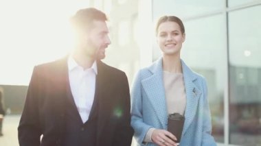 Çekici işkadını kahve gülümseyen ortağı bakmak ve Ofis Binası, yürüme ile. Executive yöneticileri kentsel Caddesi üzerinde çalışacak ön görünümü. Şehir yürüyüş kavramı. Yüksek çözünürlük. İş tarzı. Bahar stili.