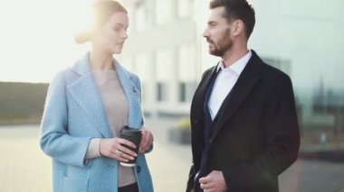 Çekici işkadını kahve gülümseyen ortağı bakmak ve Ofis Binası, yürüme ile. Executive yöneticileri kentsel Caddesi üzerinde çalışacak ön görünümü. Şehir yürüyüş kavramı. Yüksek çözünürlük. İş tarzı. Bahar stili.