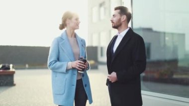 Çekici işkadını kahve gülümseyen ortağı bakmak ve Ofis Binası, yürüme ile. Executive yöneticileri kentsel Caddesi üzerinde çalışacak ön görünümü. Şehir yürüyüş kavramı. Yüksek çözünürlük. İş tarzı. Bahar stili.