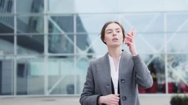 Genç başarılı iş kadını ofis binasının yakınında bir yürüyüş yapıyor. Şık, ciddi görünüyorsun. Klasik takım elbise giyiyor. Kendine güvenen bir yürüyüş. İş yaşam tarzı. Güzel kadın.