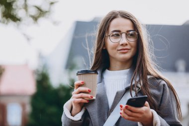 Genç kadın manifatura veya Smartphone kullanarak