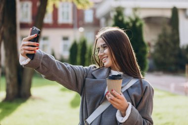 Genç kadın manifatura veya Smartphone kullanarak