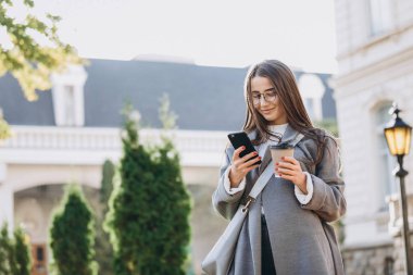 Genç kadın manifatura veya Smartphone kullanarak