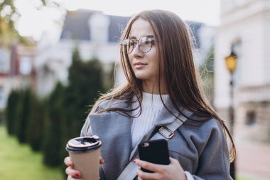 Genç kadın manifatura veya Smartphone kullanarak