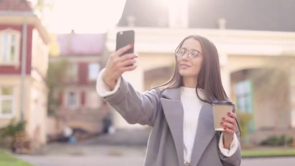 Νέα Γυναίκα Μηνύματα Χρήση Smartphone Και Πίνοντας Καφέ Στο Δρόμο — Αρχείο Βίντεο