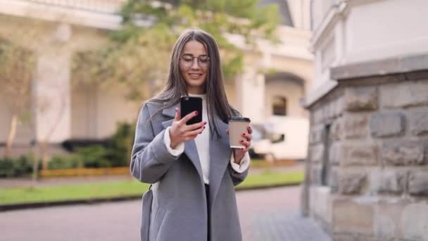 Mujer Joven Mensajes Texto Uso Teléfonos Inteligentes Beber Café Calle — Vídeos de Stock