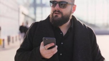 Telefonun ses tanıma kullanarak bir adamın portresi ve tatil turist konuşma kişisel asistan doğal dil kullanıcı arayüzü Havaalanı Terminali yakınında cep telefonu bakıyor.