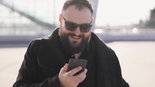 一名男子使用手机的语音识别和在酒店机场航站楼附近看手机的肖像在度假旅游语音个人助理自然语言用户界面 — 图库视频影像
