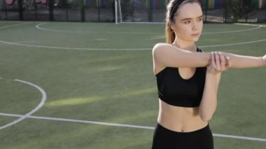Gündoğumu ile güneşin içinde belgili tanımlık geçmiş vasıl uzanan bir fitness kadın profili silüeti. Açık havada kadar ısınma sağlıklı genç bir kadın. O onun kol ve bacak Germe.
