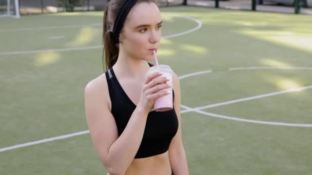 运动妇女持有浮红排毒冰沙后健身锻炼 — 图库视频影像
