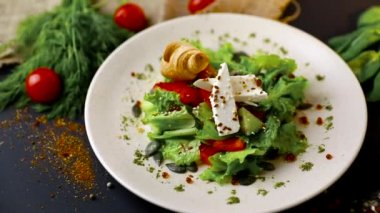 Taze salatalık, domates, tatlı biber, marul, kırmızı soğan, beyaz peynir ve zeytin zeytinyağı ile Yunan salatası. Sağlıklı yemek, en iyi manzara. Siyah arka plan . Yavaş mo
