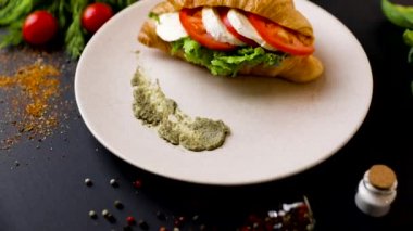 Mozzarella ve domates ile kahvaltı kruvasan sandviç. Üst te. sebze ile siyah arka plan. Yavaş mo