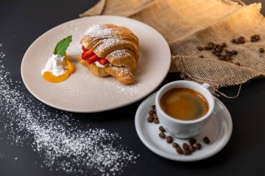 Taze kruvasan, bir fincan kahve ve siyah arka planda çilek reçeli ile kahvaltı, Slow-mo