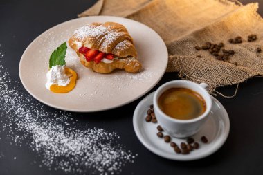 Taze kruvasan, bir fincan kahve ve siyah arka planda çilek reçeli ile kahvaltı, Slow-mo