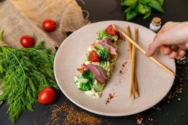 Sosis et ve sebze karışımı bir yemek ve güneş ışığı. Siyah arka plan. Ağır çekim