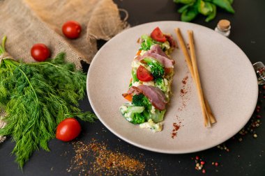 Sosis et ve sebze karışımı bir yemek ve güneş ışığı. Siyah arka plan. Ağır çekim