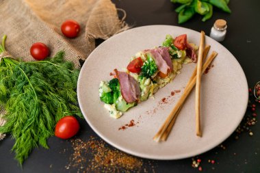 Sosis et ve sebze karışımı bir yemek ve güneş ışığı. Siyah arka plan. Ağır çekim