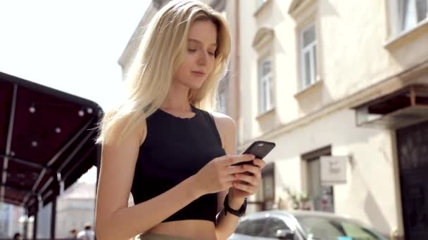 黒いシャツを着て 現代のスマートフォンを使用して美しい若い女性 プロの女性雇用者は 携帯電話の外にテキストメッセージを入力し スローモーション — ストック動画