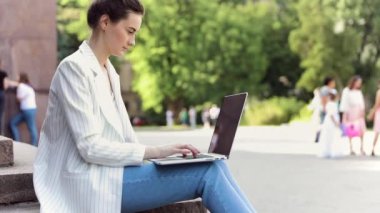 pencerenin yanında rahatça oturan bir dizüstü bilgisayar üzerinde çalışan iş kadını. kafede çalışan çekici kız 