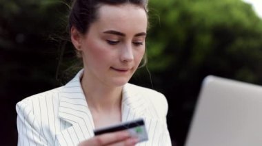 pencerenin yanında rahatça oturan bir dizüstü bilgisayar üzerinde çalışan iş kadını. kafede çalışan çekici kız 