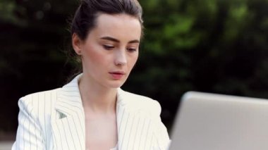 pencerenin yanında rahatça oturan bir dizüstü bilgisayar üzerinde çalışan iş kadını. kafede çalışan çekici kız 