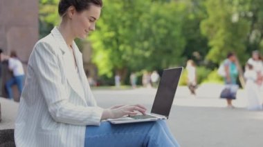 Park merkezindeki masada çalışan 20 'li yaşlarda hoş bir bayan. Güzel yüz sevinç ve mutluluk dolu bir başarıyla birbirine yakın. Öğrenci başarılı pazarlama hakkında rapor yazıyor
