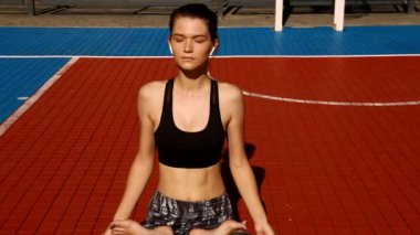 Spor kıyafetleri giyen spor kızı sokakta yoga egzersizi yapıyor, açık hava sporları, şehir tarzı.