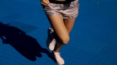 Sokakta çalışan, müzik dinlemek güzel kadın. Güzel kız Runner parlak spor giyim, spor aygıtları giyiyor: Fitness izci, kulaklık ve açık havada koşu kol bandı. Yüksek çözünürlük