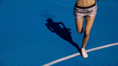 Sokakta çalışan, müzik dinlemek güzel kadın. Güzel kız Runner parlak spor giyim, spor aygıtları giyiyor: Fitness izci, kulaklık ve açık havada koşu kol bandı. Yüksek çözünürlük