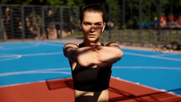 妇女舒展身体 做锻炼在街道 漂亮的运动女孩与健美的身体在明亮的运动服热身 做伸展运动前健身室外 高分辨率 — 图库视频影像