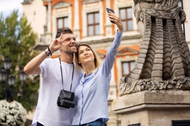Seyahat selfie çift tarihi şehirde telefon ile fotoğraf çekmek. Avrupa yaz tatili gençler gülümsüyor. Sırt çantasıyla yolculuk. Yüksek Çözünürlük. 