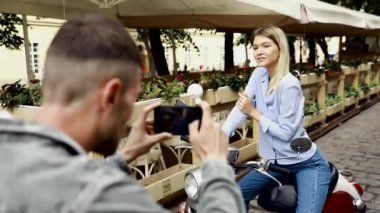 Turist Çift. Akıllı telefonu olan adam sokaktaki kadının fotoğraflarını çekiyor. Şık Kıyafetlerle Aşık Gülümseyen Genç Çift Seyahat Ediyor ve Dışarıda Fotoğraf Çekiyor. İnsanlar hafta sonu seyahat. Yüksek Çözünürlük.