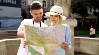 Harita ile bir gezi seyahat tatile kaç. Mutlu turist erkek ve kadın şık giysileri ile harita sokakları etrafında yürüyüş hafta sonu, seyahat. Turizm kavramı. Yüksek kaliteli görüntü.