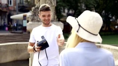 Turist çift. Kamera çekim kadının sokakta olan adam. Gülümseyen genç Çift seyahat ve fotoğrafları açık havada yapma şık giysiler içinde aşık. İnsanlar seyahat hafta sonu. Yüksek çözünürlük.