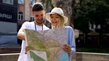 Güneşli bir günde birlikte yerel harita yı kullanan çok ırklı gezgin çift. Balayı gezisi, backpacker turist, tarihi şehir turizmi, ya da yaz tatili tatil seyahat konsepti. Yüksek Çözünürlük. 