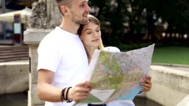 Harita ile bir gezi seyahat tatile kaç. Mutlu turist erkek ve kadın şık giysileri ile harita sokakları etrafında yürüyüş hafta sonu, seyahat. Turizm kavramı. Yüksek kaliteli görüntü.