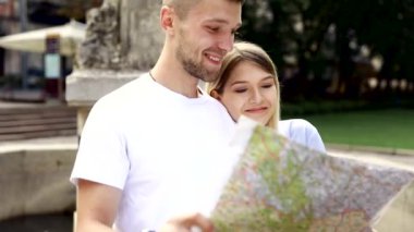 Harita ile bir gezi seyahat tatile kaç. Mutlu turist erkek ve kadın şık giysileri ile harita sokakları etrafında yürüyüş hafta sonu, seyahat. Turizm kavramı. Yüksek kaliteli görüntü.