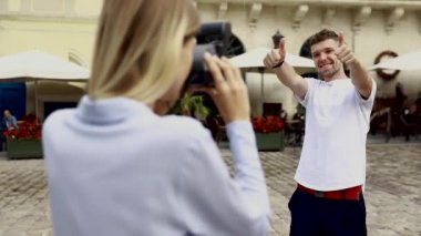 Turist çift. Kamera çekim bir adam sokakta olan kadın. Gülümseyen genç Çift seyahat ve fotoğrafları açık havada yapma şık giysiler içinde aşık. İnsanlar seyahat hafta sonu. Yüksek çözünürlük.