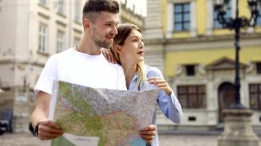 Harita ile bir gezi seyahat tatile kaç. Mutlu turist erkek ve kadın şık giysileri ile harita sokakları etrafında yürüyüş hafta sonu, seyahat. Turizm kavramı. Yüksek kaliteli görüntü.