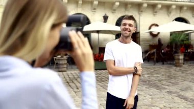 Turist çift. Kamera çekim bir adam sokakta olan kadın. Gülümseyen genç Çift seyahat ve fotoğrafları açık havada yapma şık giysiler içinde aşık. İnsanlar seyahat hafta sonu. Yüksek çözünürlük.