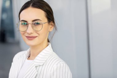 Sabah erken işe gitmeden gitmek başarılı iş kadını modern smartphone kullanarak ve kahve içme takım giyen kırpılmış görüntü