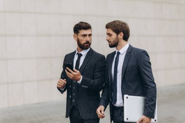 İş seyahati sırasında akıllı telefondan bir haberde birlikte tartışan iki işadamı. İş, teknoloji ve insan kavramı