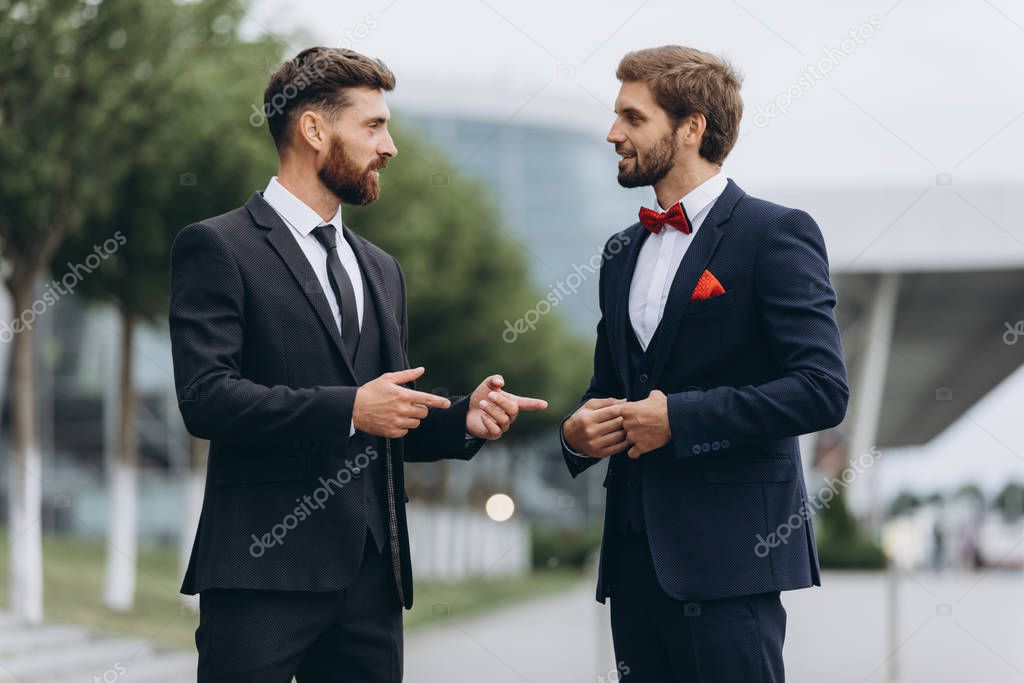  Business, technology and people concept. Image of two young businessmen communicating at meetin