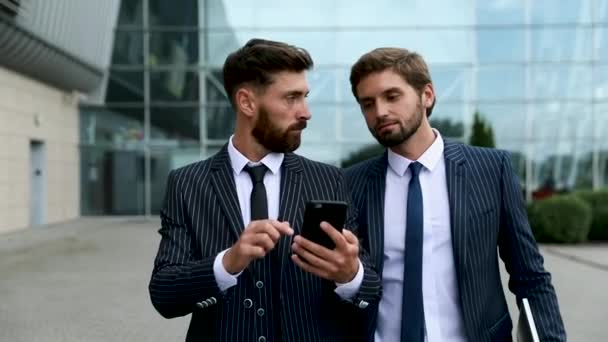 Dos Hombres Negocios Discutiendo Juntos Una Noticia Teléfono Inteligente Durante — Vídeo de stock