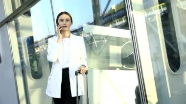 Beyaz gömlekli, kendine güvenen beyaz iş kadını Modern Office Binası 'nın dışında telefonla konuşuyor. Orta Uzun Düşük Açı 4K Yavaş Hareket Kurumsal Çekim Yaklaşık 360 Kamera ile