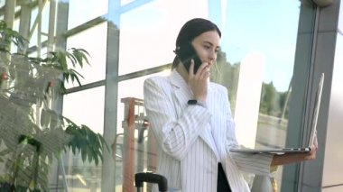 Beyaz gömlekli, kendine güvenen beyaz iş kadını Modern Office Binası 'nın dışında telefonla konuşuyor. Orta Uzun Düşük Açı 4K Yavaş Hareket Kurumsal Çekim Yaklaşık 360 Kamera ile