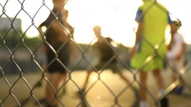 Çocuklar bir köyde gün ışığında futbol oynuyorlar. Yavaş çekim.