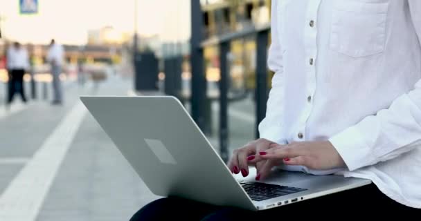 Mulher de negócios sentada na parada de bonde e trabalhando no laptop — Vídeo de Stock